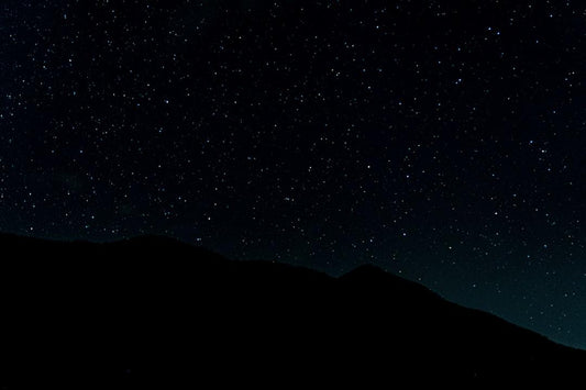 Starry night sky over dark mountain silhouette, unrelated to dried black soldier fly benefits in animal feed.