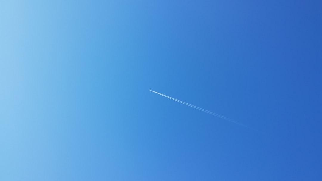 Clear blue sky with a diagonal jet contrail, illustrating the concept of "powder blue," relevant to isopod habitat color themes.