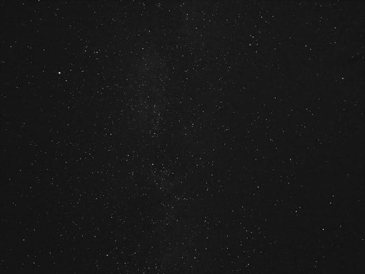 A dense field of tiny, scattered white specks on a black background, resembling stars, symbolizing the unseen benefits of dried black soldier fly for pets.