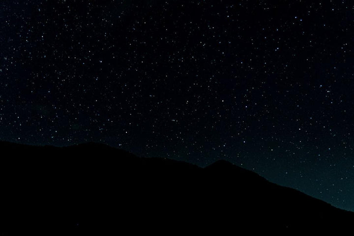 Starry night sky above a dark mountain silhouette, All Angles Creatures nature theme