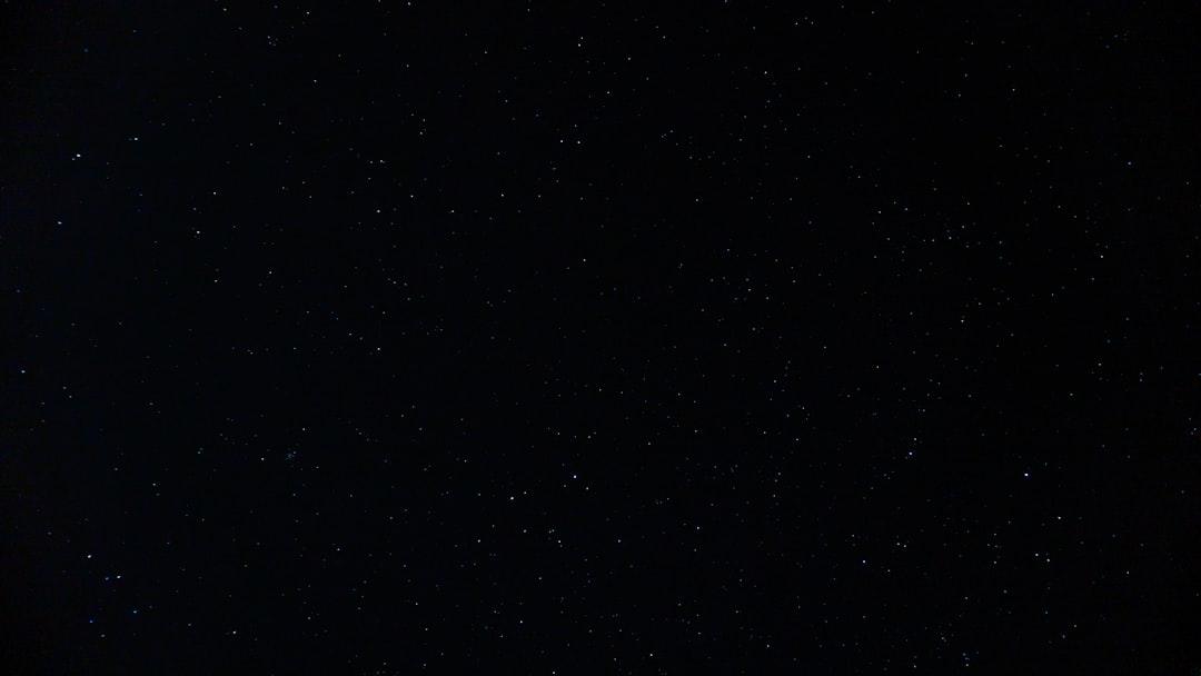 A dark image with scattered white specks resembling stars in the night sky, unrelated to dried Black Soldier Fly benefits for pets.